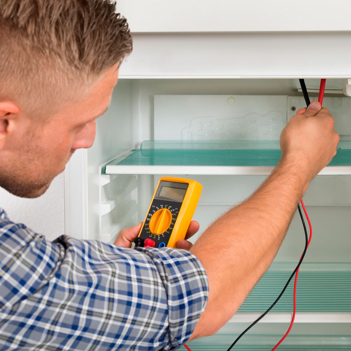 Foto de Técnico revisando estado de nevera Foto de Técnico revisando estado de nevera