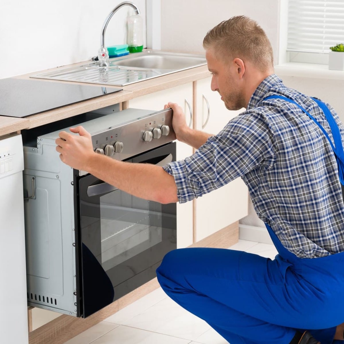 Foto de Técnico instalando horno Foto de Técnico instalando horno